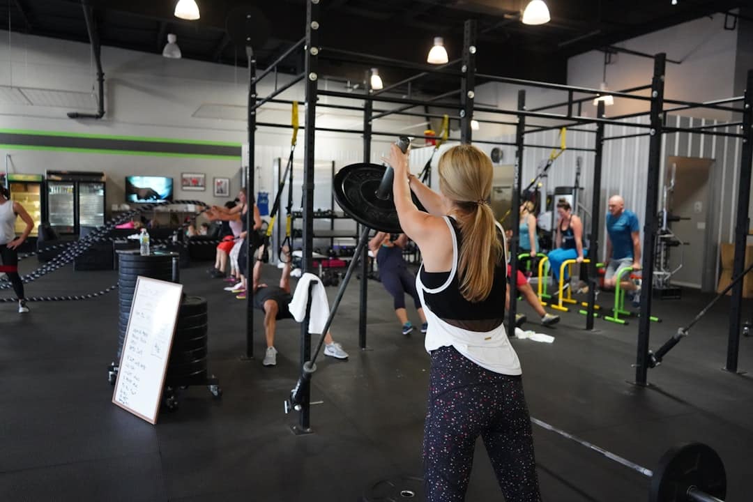 A group of people demonstrating workout consistency by training together in a kettlebell fitness class.