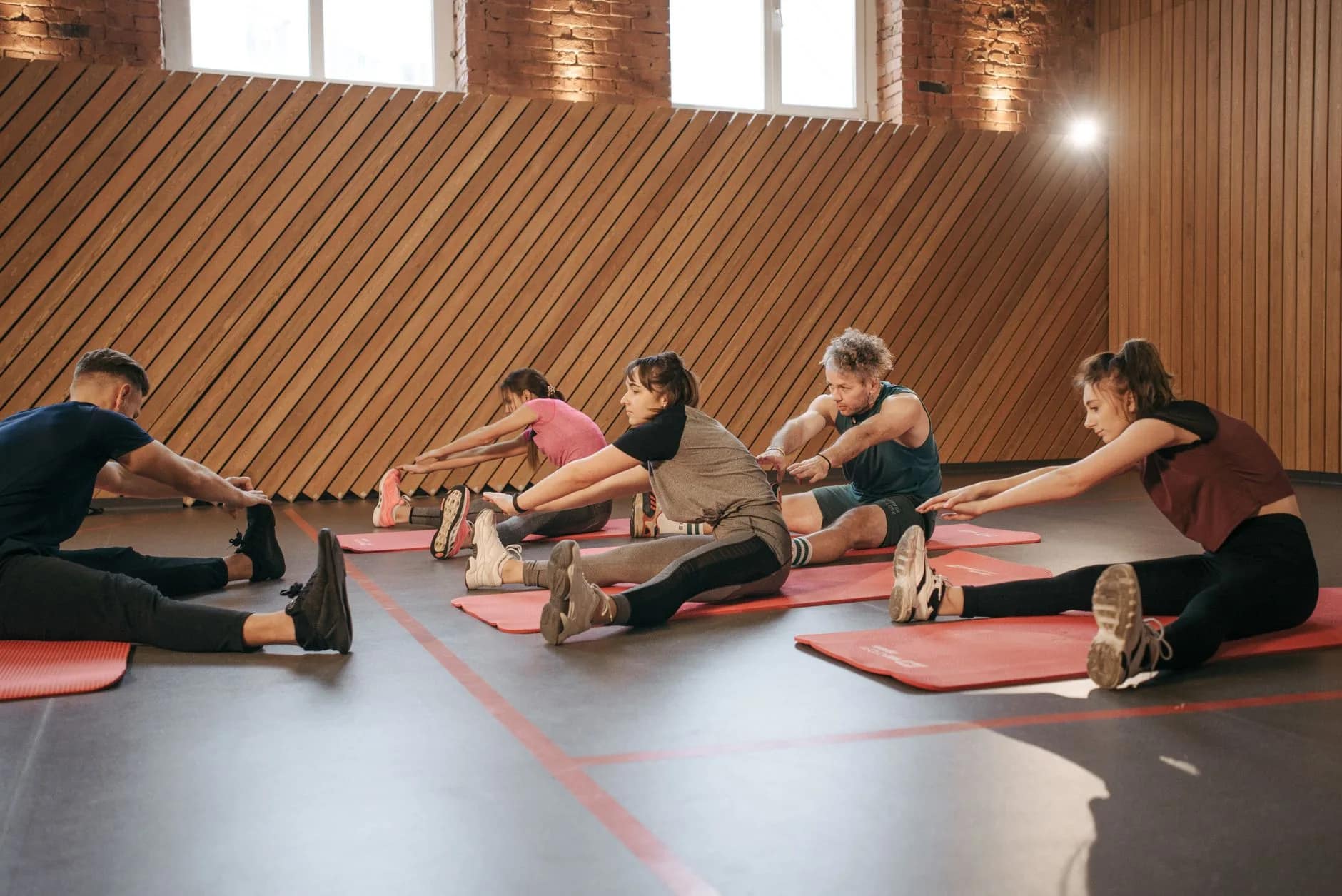 Wide shot of a busy gym floor with members training, representing the revenue managed by gym membership billing software